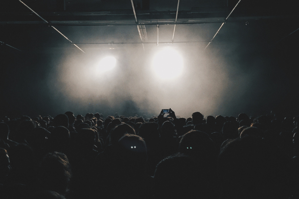 Crowd of people gathered under stage lights