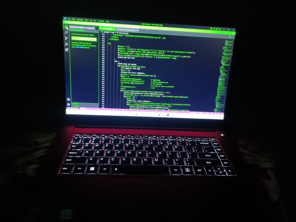 Backlit keyboard and glowing code editor at night