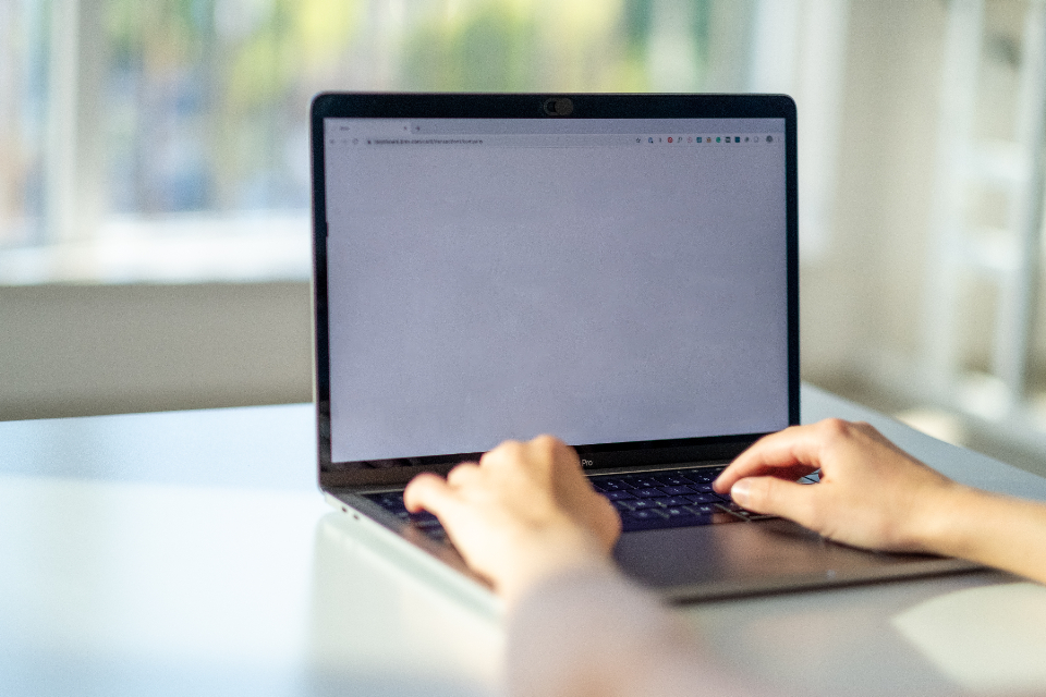 Person typing a form on a laptop