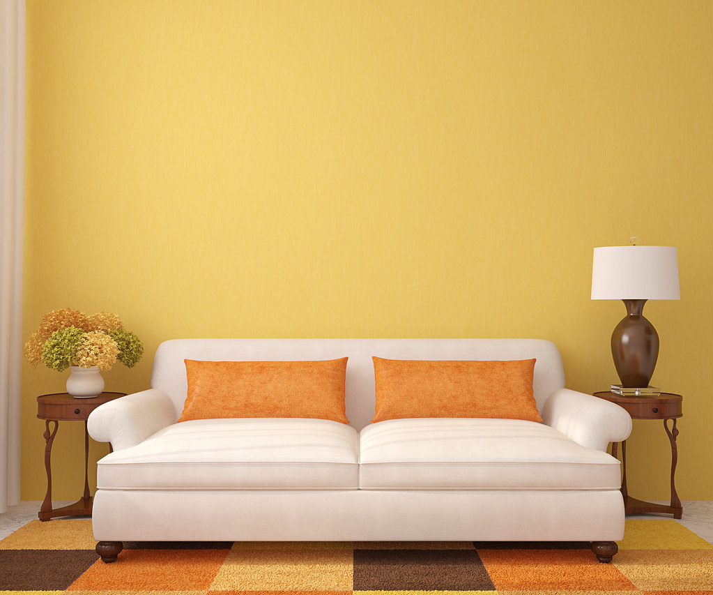 Bright living room with white sofa and orange accents