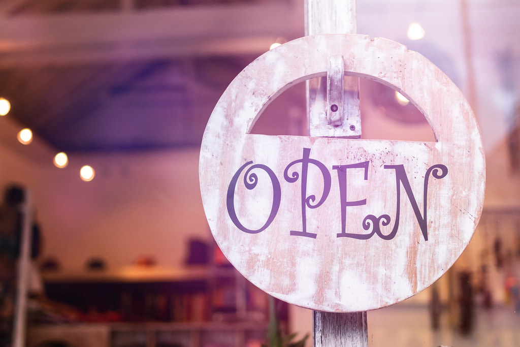 Open sign hanging in a shop window