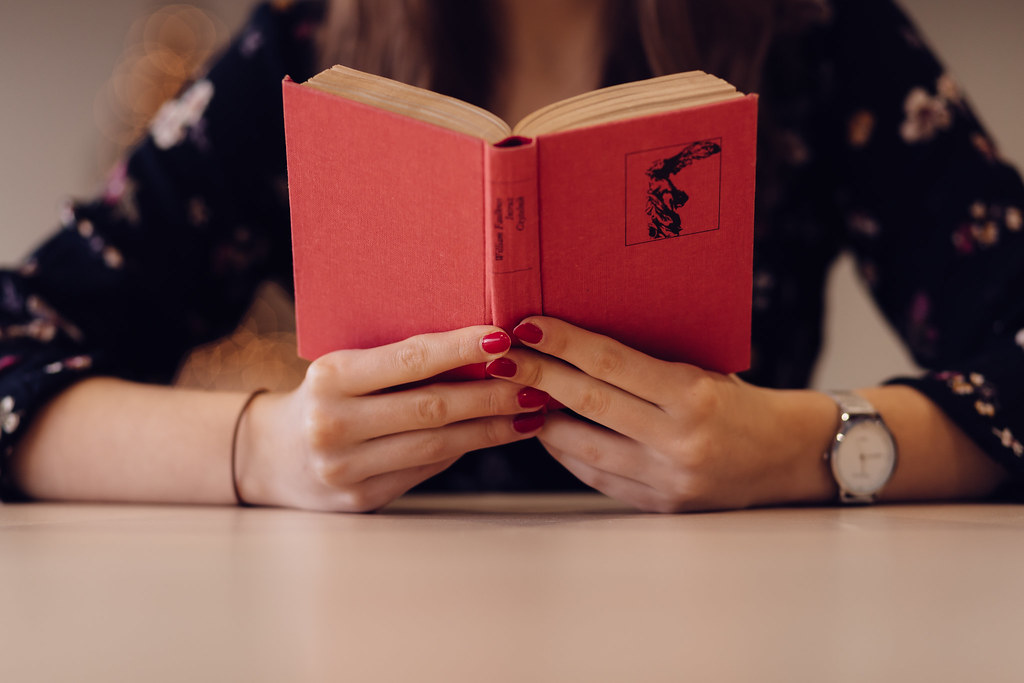 Hands holding an open book while reading