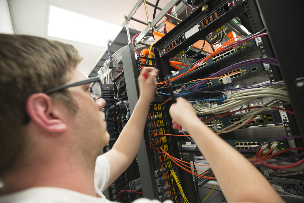 Technician working on network cabling in a rack