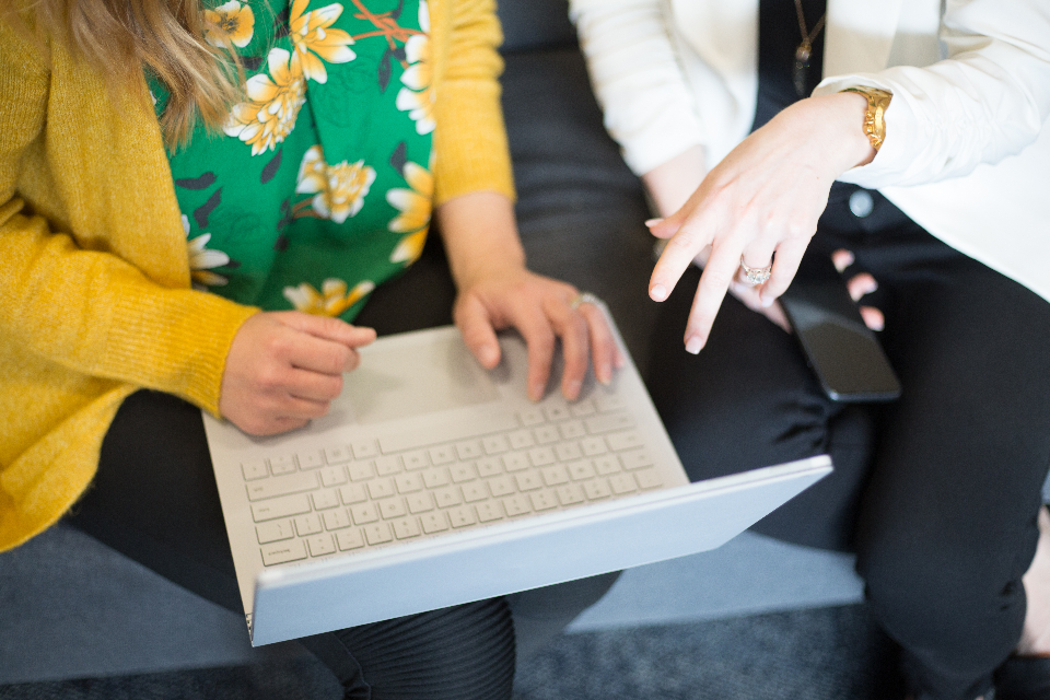 Two colleagues collaborating over a laptop