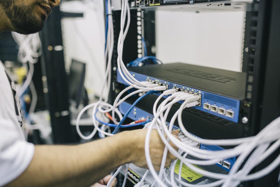 Technician working on network switch cabling