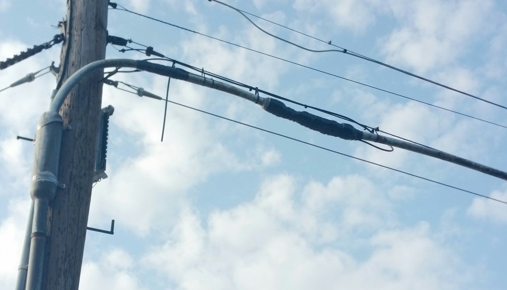 Telephone pole with copper lines against the sky