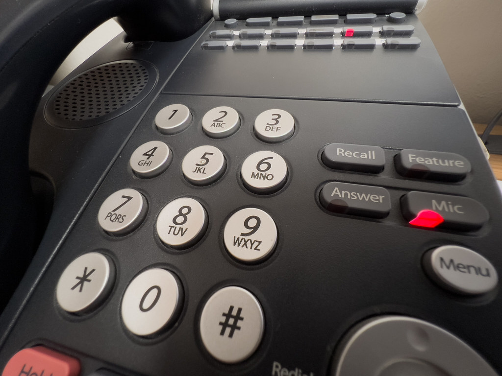 Office desk phone keypad close-up