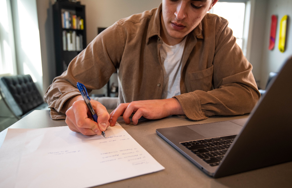 Hands working on a laptop at a desk