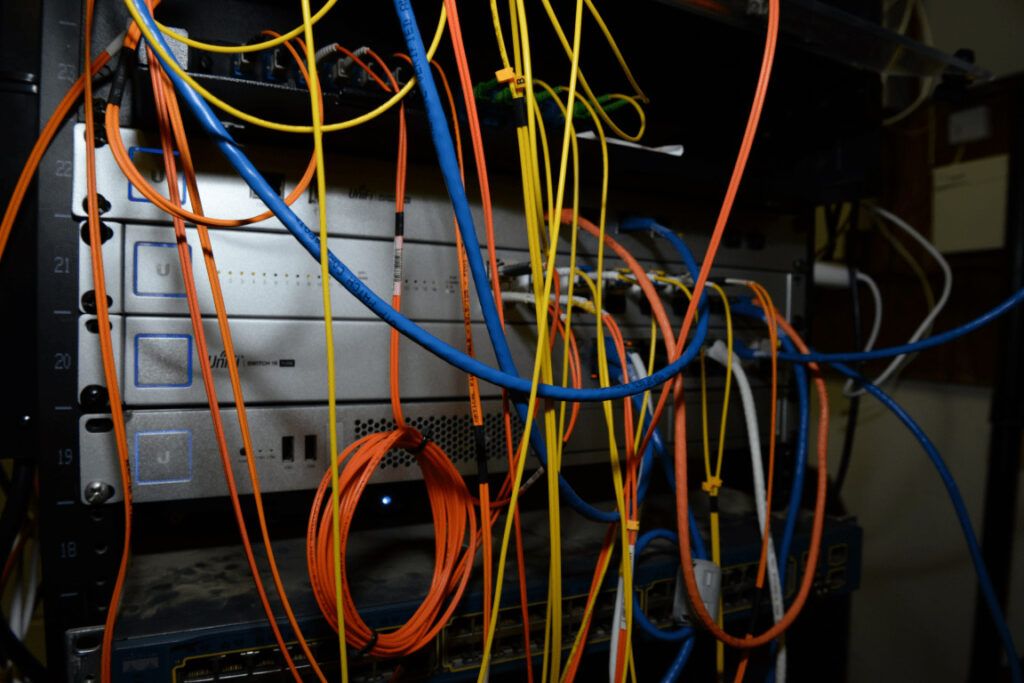 EFTA00002522 - Cluttered server rack filled with colorful cables and networking equipment