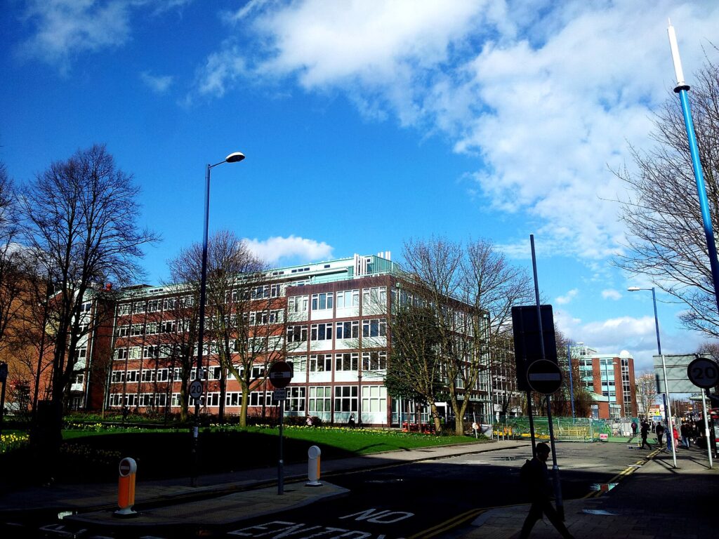 High school building exterior is pictured in a town or city landscape