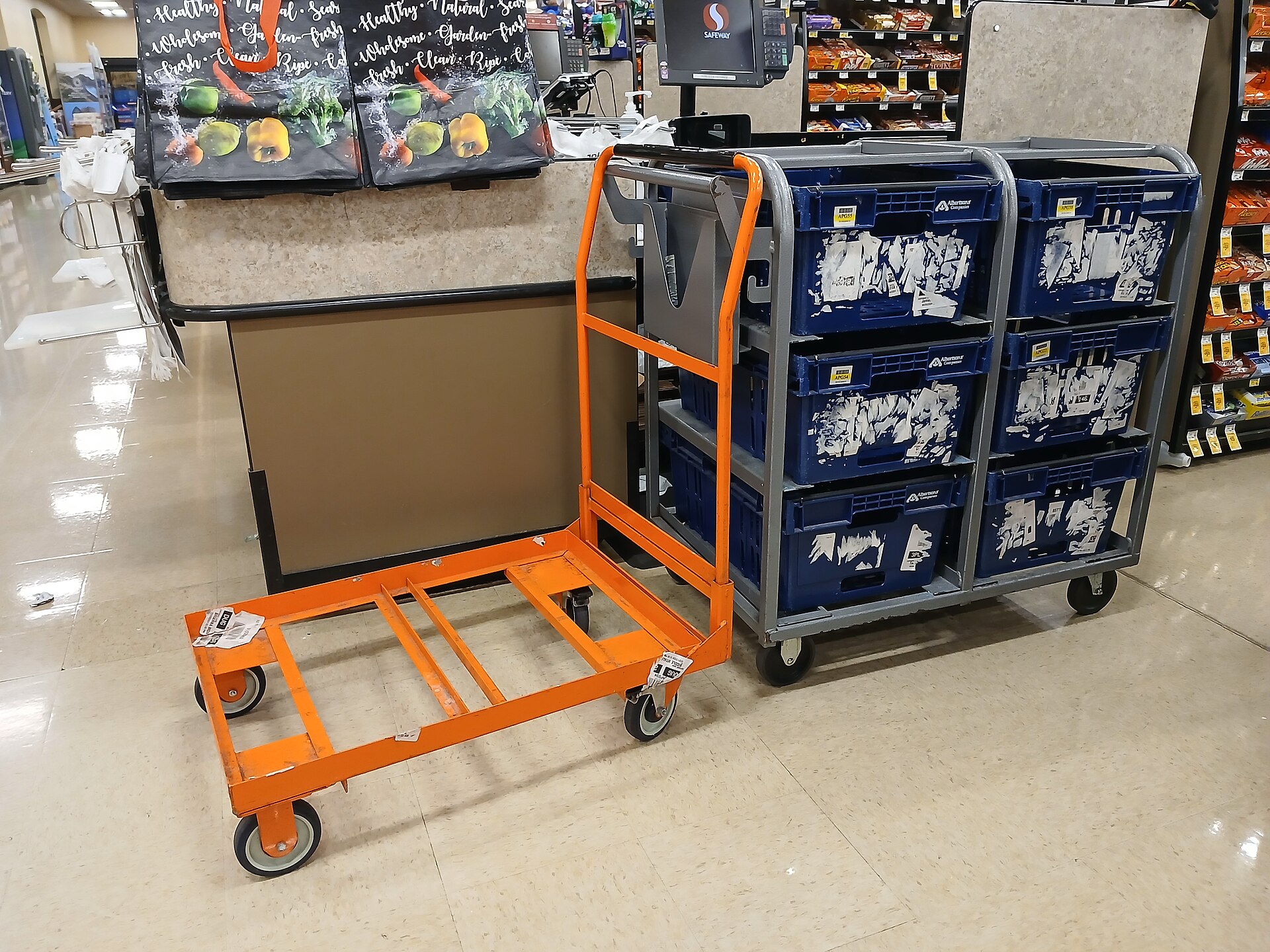 Orange hand truck pulling a variety of blue cartons