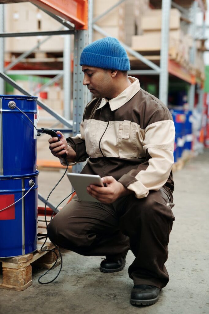 Warehouse technician scanning inventory with a handheld device and tablet
