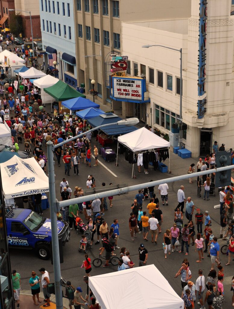 Crowd browsing vendor booths at an outdoor street festival