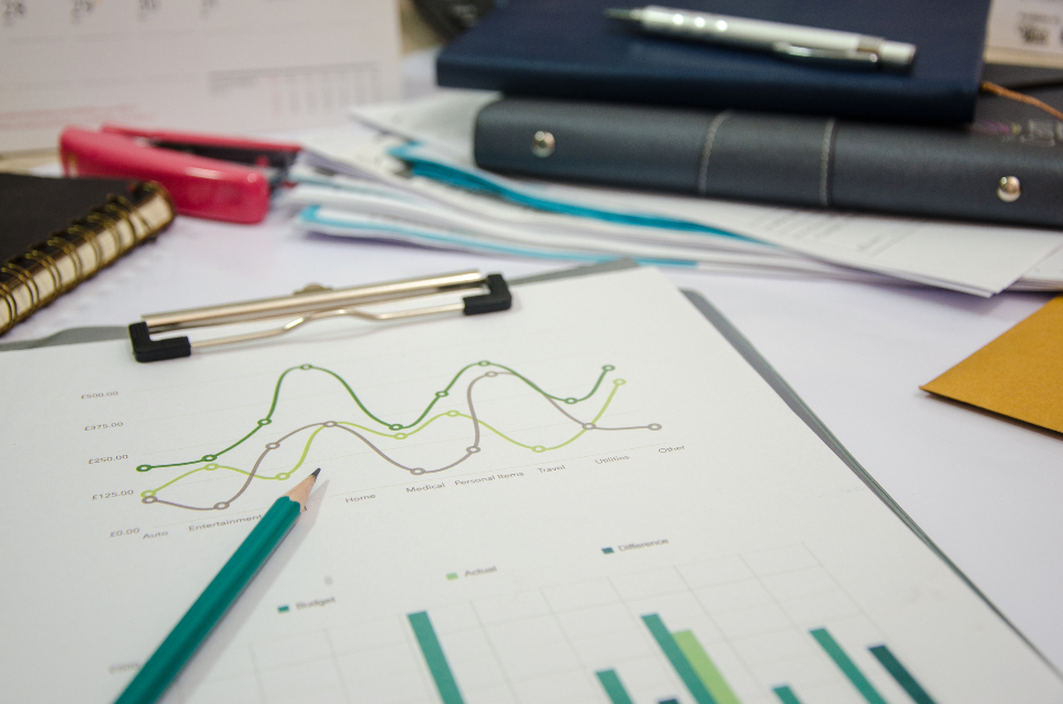 Printed analytics report with line and bar charts on a clipboard